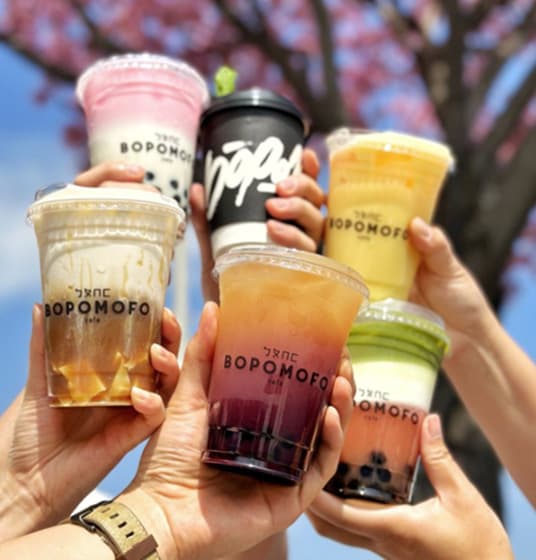 Six hands holding up a fancy drink